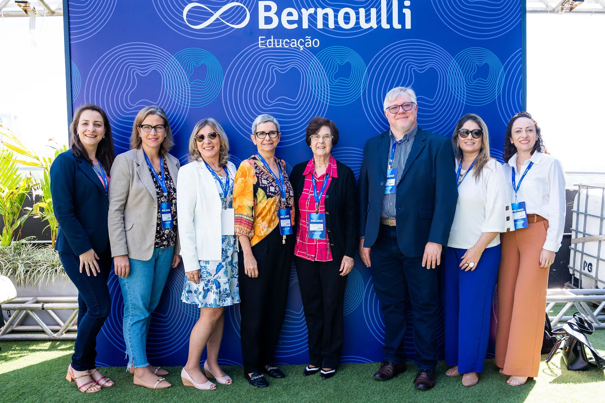 Participantes do evento em frente ao painel do Bernoulli Educação