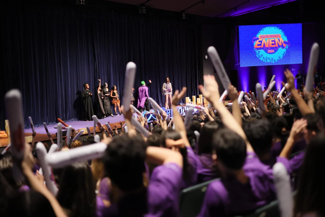 Professores fantasiados e alunos interagindo durante evento do Pré-vestibular Bernoulli "Aquecimento Enem 2024".