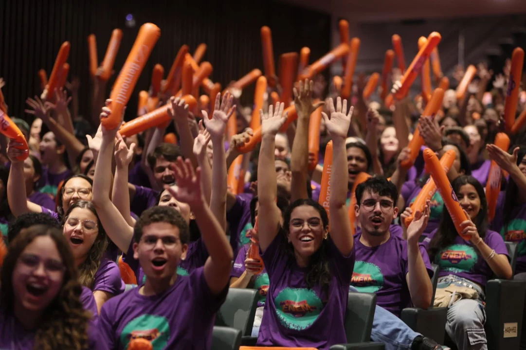 Alunos do Colégio e Pré-vestibular Bernoulli animados, levantando as mãos e interagindo com entusiasmo durante o evento Aquecimento Enem 2024.